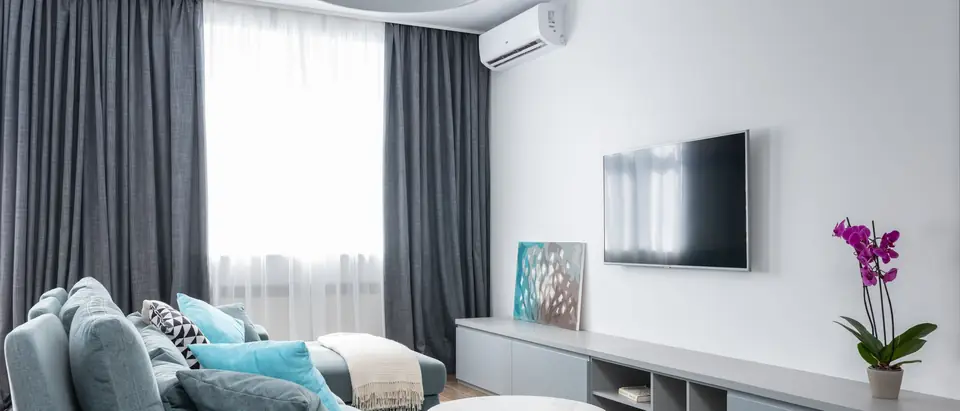 A bright living room with a ductless air conditioner by the window