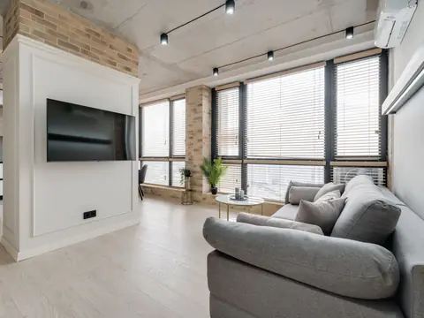 A cool, bright living room with a ductless air conditioner high on the wall