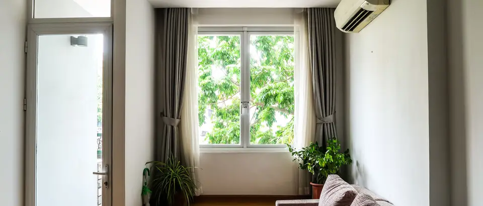 A bright living room with a ductless air conditioner above the window