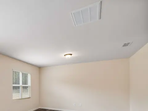 A ceiling supply vent in a bright, empty room