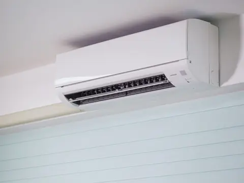 A white ductless air conditioner on a bright wall