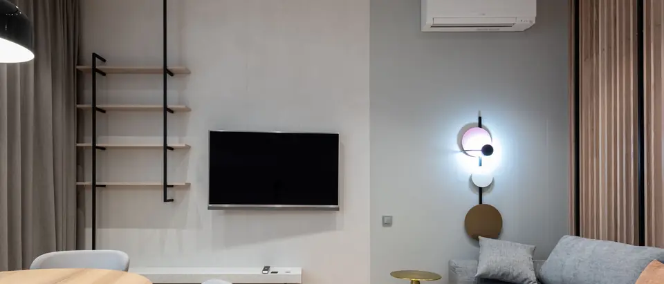 A light living room with a ductless air conditioner above the sofa